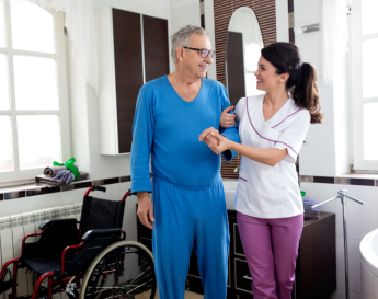 caregiver assist the elderly man to stand