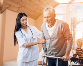 caregiver helping the elderly to stand