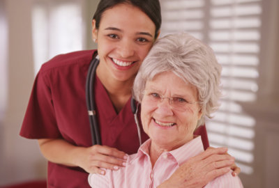 caregiver holding the elderly woman's shoulders