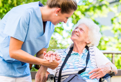 caregiver holding the hand of the elderly woman