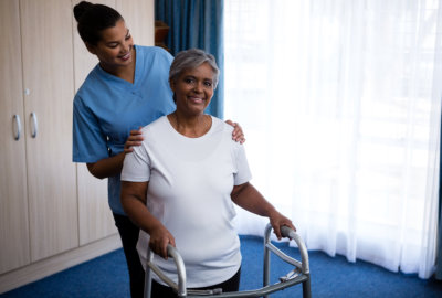 caregiver aiding elderly woman in walking